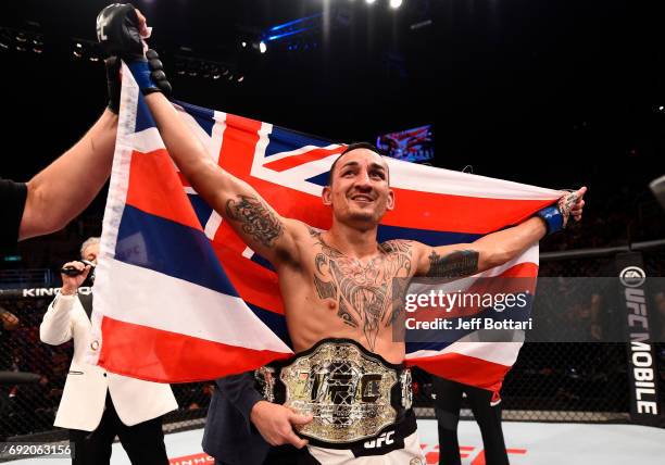 Max Holloway celebrates after his TKO victory over Jose Aldo of Brazil in their UFC featherweight championship bout during the UFC 212 event at...