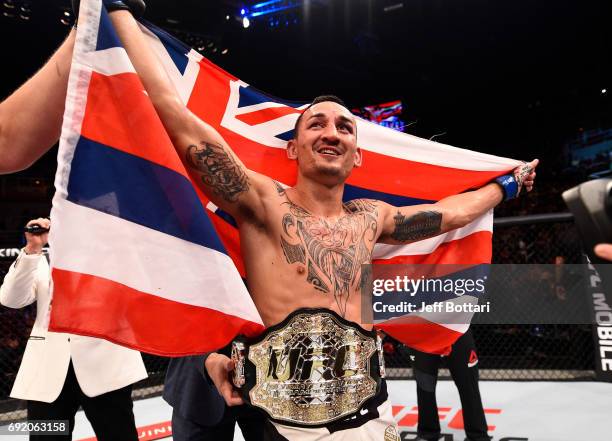 Max Holloway celebrates after his TKO victory over Jose Aldo of Brazil in their UFC featherweight championship bout during the UFC 212 event at...
