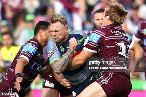 Blake Austin of the Raiders is tackled during the round 13 NRL match between the Manly Sea Eagles and the Canberra Raiders at Lottoland on June 4,...