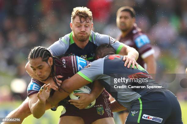 Martin Taupau of the Sea Eagles is tackled during the round 13 NRL match between the Manly Sea Eagles and the Canberra Raiders at Lottoland on June...