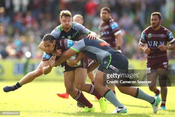 Martin Taupau of the Sea Eagles is tackled during the round 13 NRL match between the Manly Sea Eagles and the Canberra Raiders at Lottoland on June...