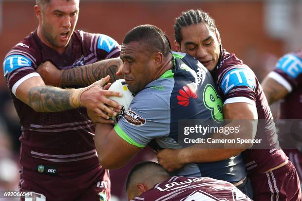 Junior Paulo of the Raiders is tackled during the round 13 NRL match between the Manly Sea Eagles and the Canberra Raiders at Lottoland on June 4,...