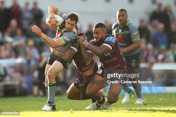 Aiden Sezer of the Raiders is tackled during the round 13 NRL match between the Manly Sea Eagles and the Canberra Raiders at Lottoland on June 4,...