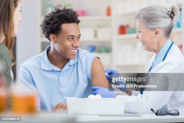 doctor prepares to give man a vaccine - pharmacy vaccination stock pictures, royalty-free photos & images