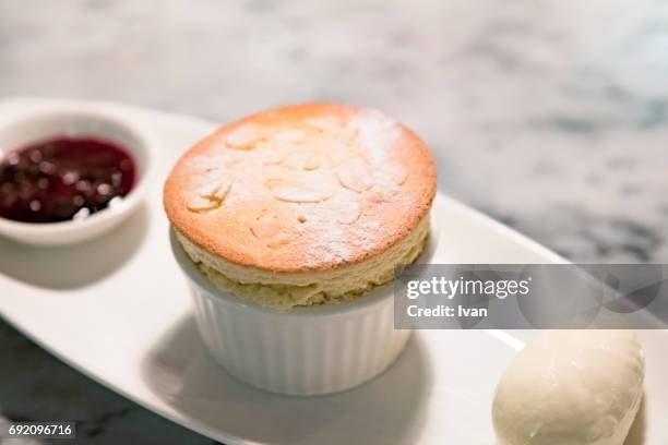 platters of almond and vanilla souffle dessert with ice cream and red berry sauce - souffle stock pictures, royalty-free photos & images