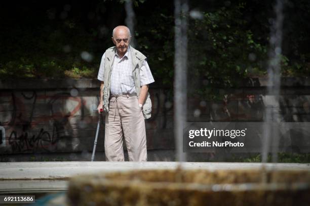An elderly man with a crutch is seen in a park in the center of Bydgoszcz, Poland on 3 June, 2017.