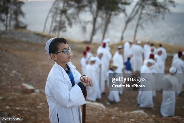 Child of the Samaritan community prays as he prepares to take part in the traditional pilgrimage marking the holiday of Shavuot, atop Mount Gerizim...