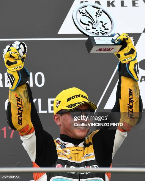 Racing Team rider Spanish Juanfran Guevara, third, celebrates on the podium after winning the Moto 3 Grand Prix at the Mugello race track on June 4,...