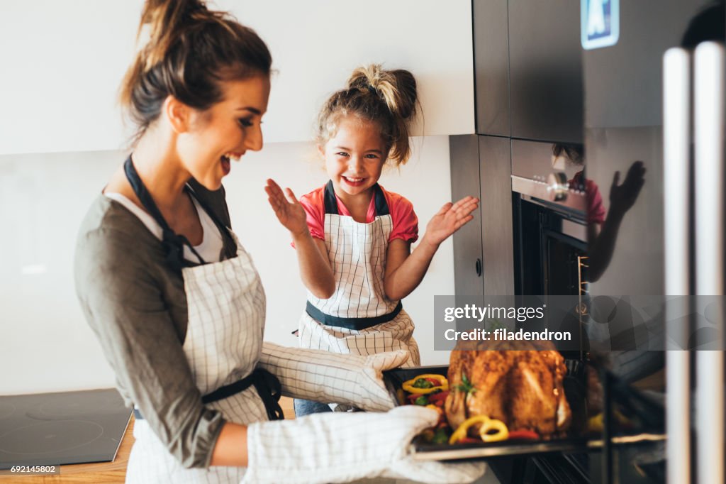 Mother taking the dinner out of the oven