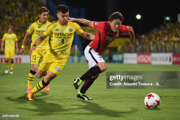 Tomoya Ugajin of Urawa Red Diamonds and Cristiano of Kashiwa Reysol compete for the ball during the J.League J1 match between Kashiwa Reysol and...