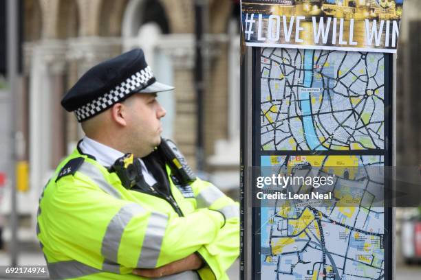 Police officer stands guard next to a sign reading "ISIS Will Lose. Love Will Win", following last night's London terror attack, on June 4, 2017 in...