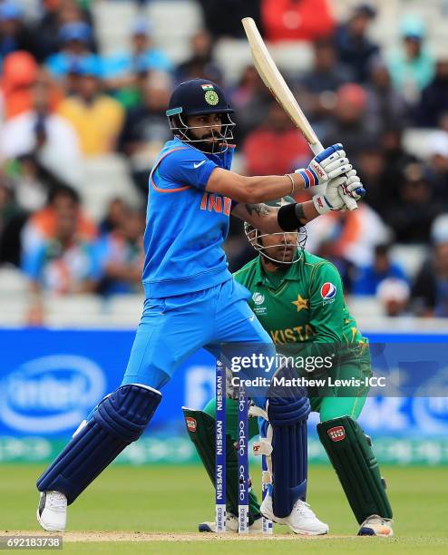 Virat Kohli of India hits the ball towards the boundary, as Sarfraz Ahmed of Pakistan looks on during the ICC Champions Trophy match between India...