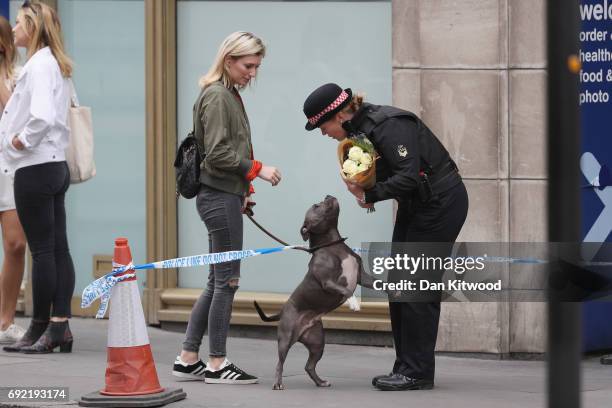 Woman and her dog with a female police officer near to the scene of last night's terror attack on June 4, 2017 in London, England. Police continue to...