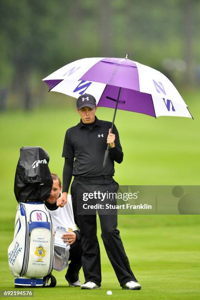 Matthew Fitzpatrick of England shelters from the rain while speaking to his caddie during day four of the Nordea Masters at Barseback Golf & Country...