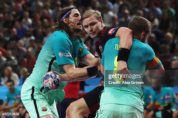 Aron Palmarsson of Veszprem is challenged by Viran Morros de Argila and Viktor Tomas Gonzalez of Barcelona during the VELUX EHF FINAL4 3rd place...