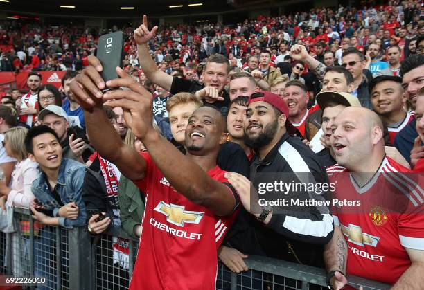 Patrice Evra of Manchester United '08 XI takes a selfie with fans after the Michael Carrick Testimonial match between Manchester United '08 XI and...