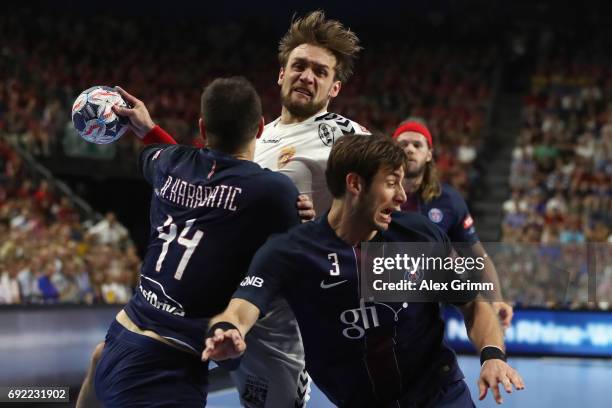 Luka Cindric of Vardar is challenged by Nikola Karabatic and Uwe Gensheimer of Paris during the VELUX EHF FINAL4 final between Paris Saint-Germain...