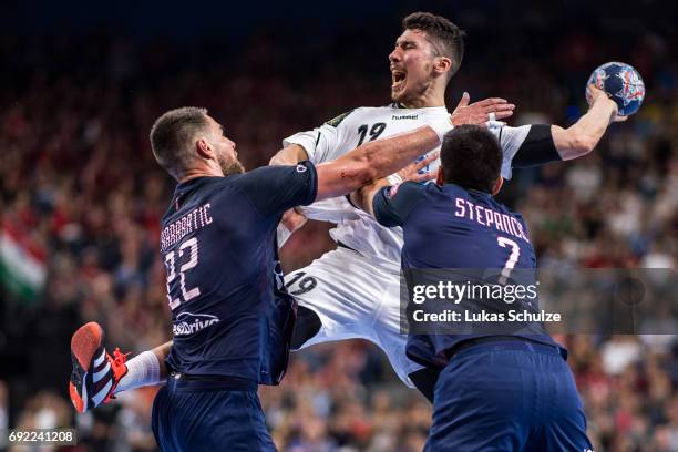 Alex Dujshebaev of Vardar is attacked by Luka Karabatic and Luka Stepancic of Paris during the VELUX EHF FINAL4 Final match between Paris...