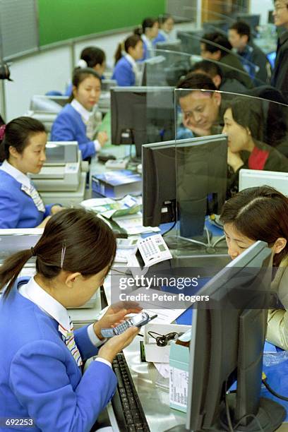 Chinese consumers buy CDMA handsets and receive new phone numbers at a salesroom of China Unicom Group January 9, 2002 in Beijing, China. Unicom...