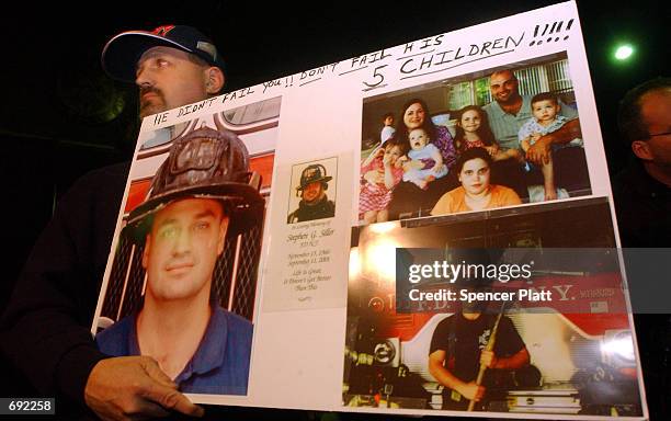 Frank Siller holds pictures of his late brother, New York City fire fighter Stephen Siller, at a rally for victims of the September 11 attacks on the...