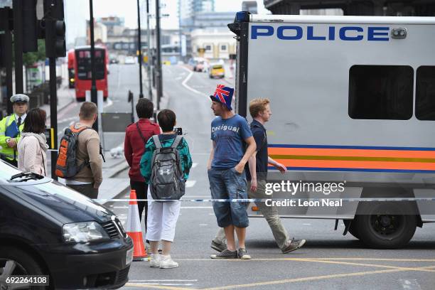 Tourists paas London Bridge which is cordoned off following last night's terrorist attack on June 4, 2017 in London, England. Police are...