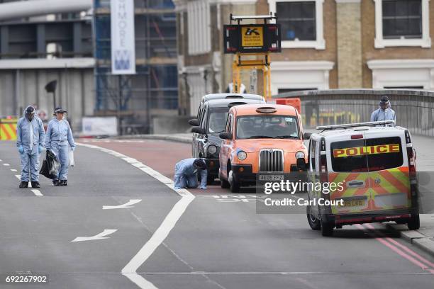 Forensic officer checks under a taxi as they work on London Bridge following last night's terrorist attack on June 4, 2017 in London, England. Police...