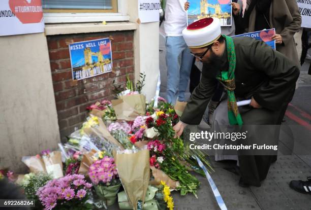 Man lay flowers and show support for victims near the scene of last night's terrorist attack on June 4, 2017 in London, England. Police continue to...