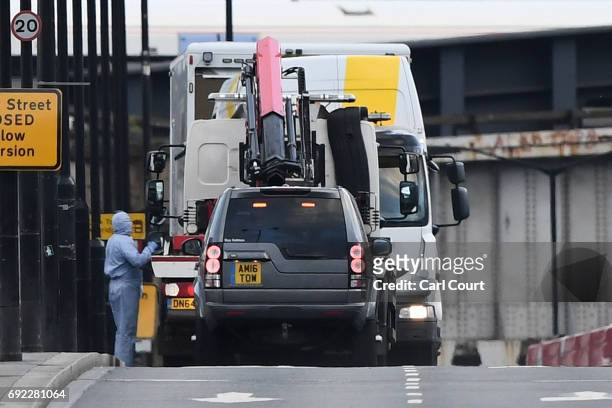 The white van used in the attack is loaded onto a truck on London Bridge on June 4, 2017 in London, England. Police are investigationg last night's...
