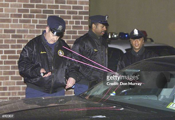 Philadelphia Police Crime Scene Investigators examine and try to recreate the trajectory of three bullets that struck and seriously injured...
