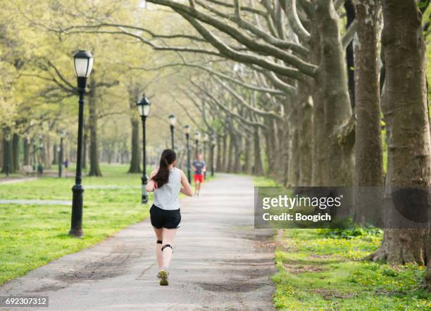 people exercising outdoors on running path riverside park nyc - riverside park manhattan stock pictures, royalty-free photos & images