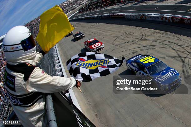 Jimmie Johnson, driver of the Lowe's Chevrolet, takes the checkered and caution flag to win the Monster Energy NASCAR Cup Series AAA 400 Drive for...