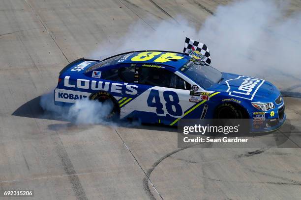 Jimmie Johnson, driver of the Lowe's Chevrolet, celebrates with a burnout after winning the Monster Energy NASCAR Cup Series AAA 400 Drive for Autism...