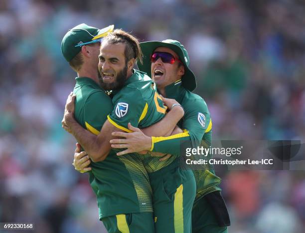 Imran Tahir of South Africa is congratulated by Morne Morkel and AB De Villiers after he takes a wicket during the ICC Champions Trophy Group B match...