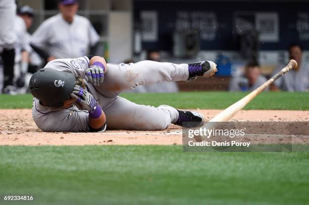 Gerardo Parra of the Colorado Rockies falls to the ground after being hit with a pitch during the eighth inning of a baseball game against the San...