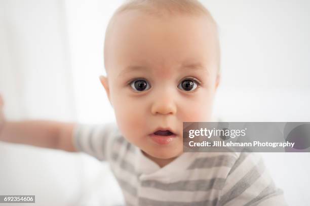 11 month old baby close up in gray stripes - natural light - close to stockfoto's en -beelden