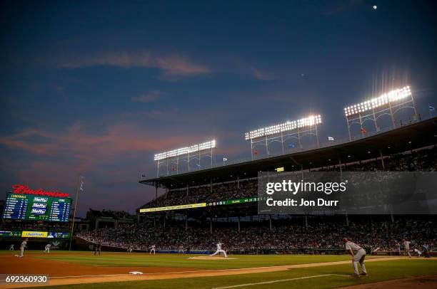 Hector Rondon of the Chicago Cubs pitches against Paul DeJong of the St. Louis Cardinals during the sixth inning at sunset as the moon rises at...