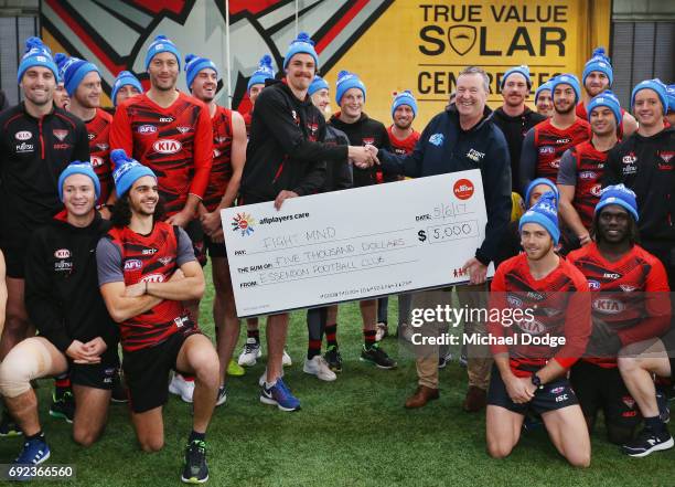 Bombers legend Neale Daniher poses with nephew Joe Daniher of the Bombers and his teammates during a cheque presentation to fight MND at the Essendon...
