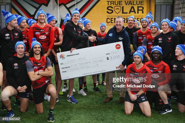 Bombers legend Neale Daniher poses with nephew Joe Daniher of the Bombers and his teammates during a cheque presentation to fight MND at the Essendon...