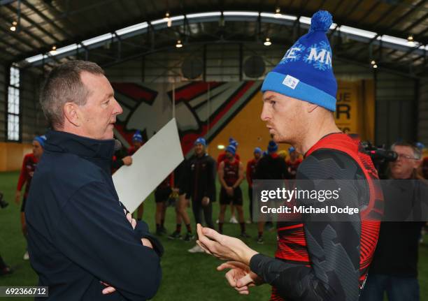 Bombers legend Neale Daniher listens to Brendon Goddard of the Bombers during a cheque presentation to fight MND at the Essendon Football Club on...