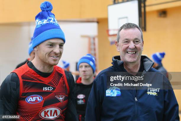 Bombers legend Neale Daniher listens to Brendon Goddard of the Bombers before a cheque presentation to fight MND at the Essendon Football Club on...