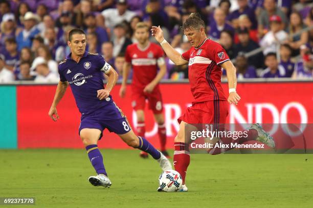 Bastian Schweinsteiger of Chicago Fire kicks the ball in front of Will Johnson of Orlando City SC during a MLS soccer match between the Chicago Fire...