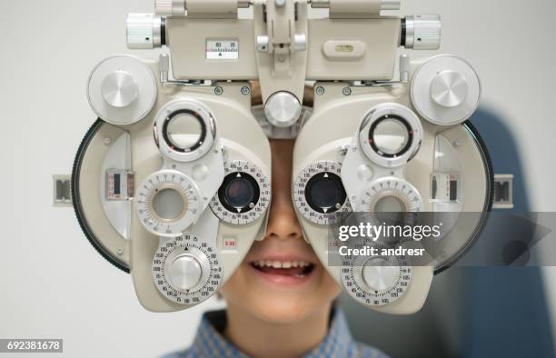 jeune patient obtenir un examen de la vue à l’opticien - réfracteur photos et images de collection