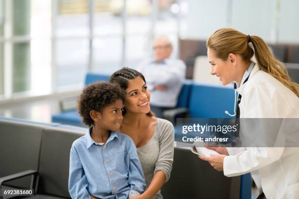 huisarts in gesprek met een moeder en zoon in het ziekenhuis - spoedeisende geneeskunde stockfoto's en -beelden