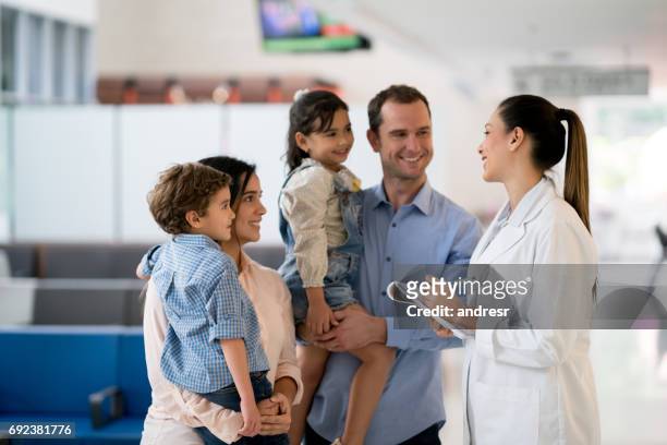 doctor talking to a family at the hospital - family with doctor stock pictures, royalty-free photos & images