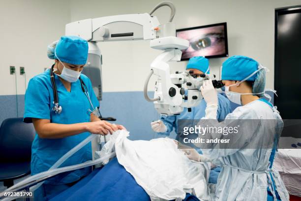 ophthalmic surgeon performing an eye surgery at the hospital - oftalmologista imagens e fotografias de stock
