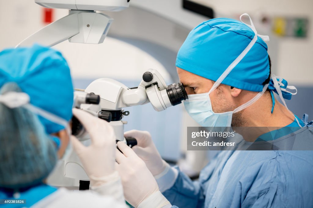 Surgeon performing an eye surgery under the microscope