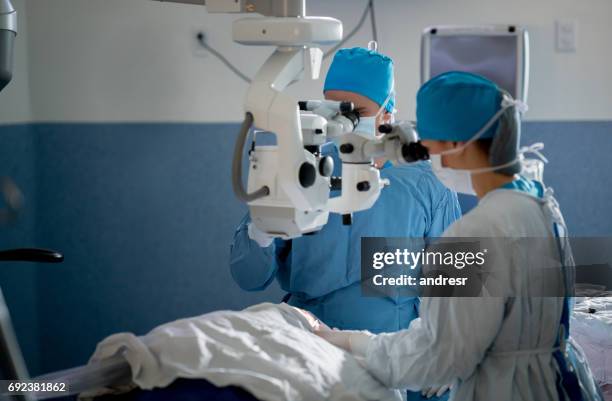 surgeons doing an ocular surgery at the hospital - ocular stock pictures, royalty-free photos & images