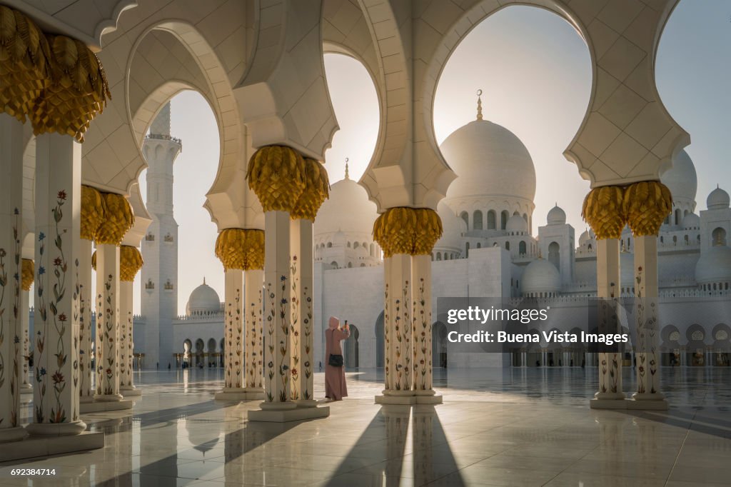 Woman with Abaya taking Pictures in a Mosque