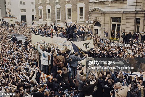 View of Chelsea Football Club team players standing on the top deck of an open top bus as they parade with the FA Cup trophy through the streets of...