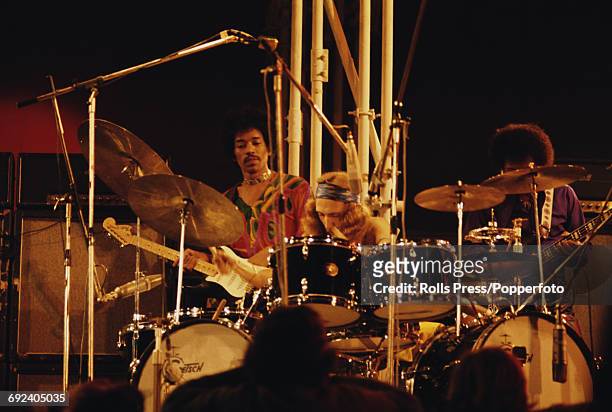 American singer, songwriter and guitarist Jimi Hendrix performs on stage with drummer Mitch Mitchell and bass guitarist Billy Cox at the Isle of...